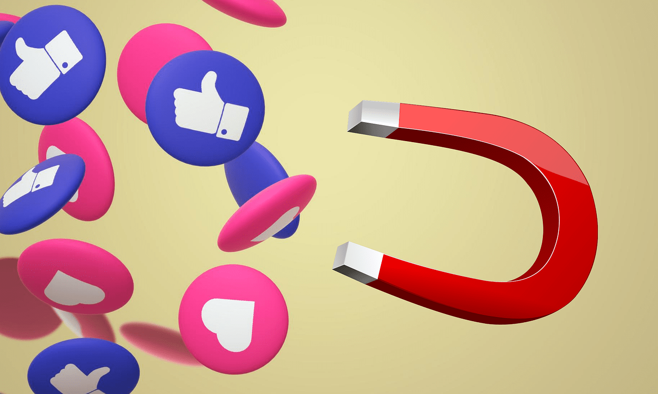A red horseshoe magnet attracting blue and pink social media icons with thumbs-up and heart symbols, representing B2B lead generation and engagement.