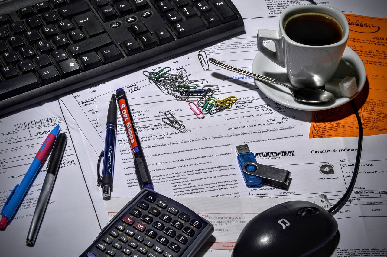 Accountant's desk with financial documents, calculator, and laptop