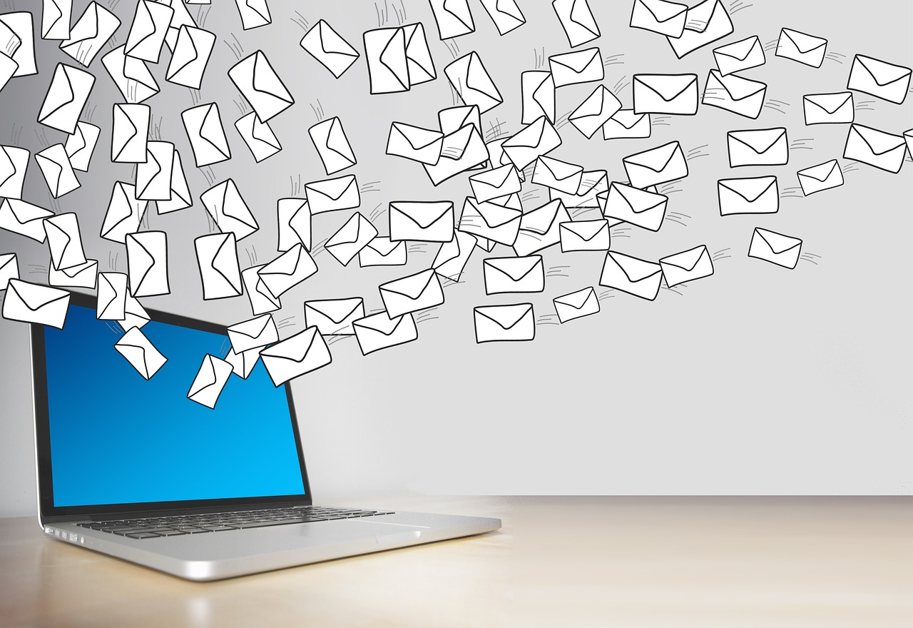 Email marketing concept showing a laptop with an open inbox, surrounded by digital icons like an envelope, charts, and target symbols, representing communication and growt
